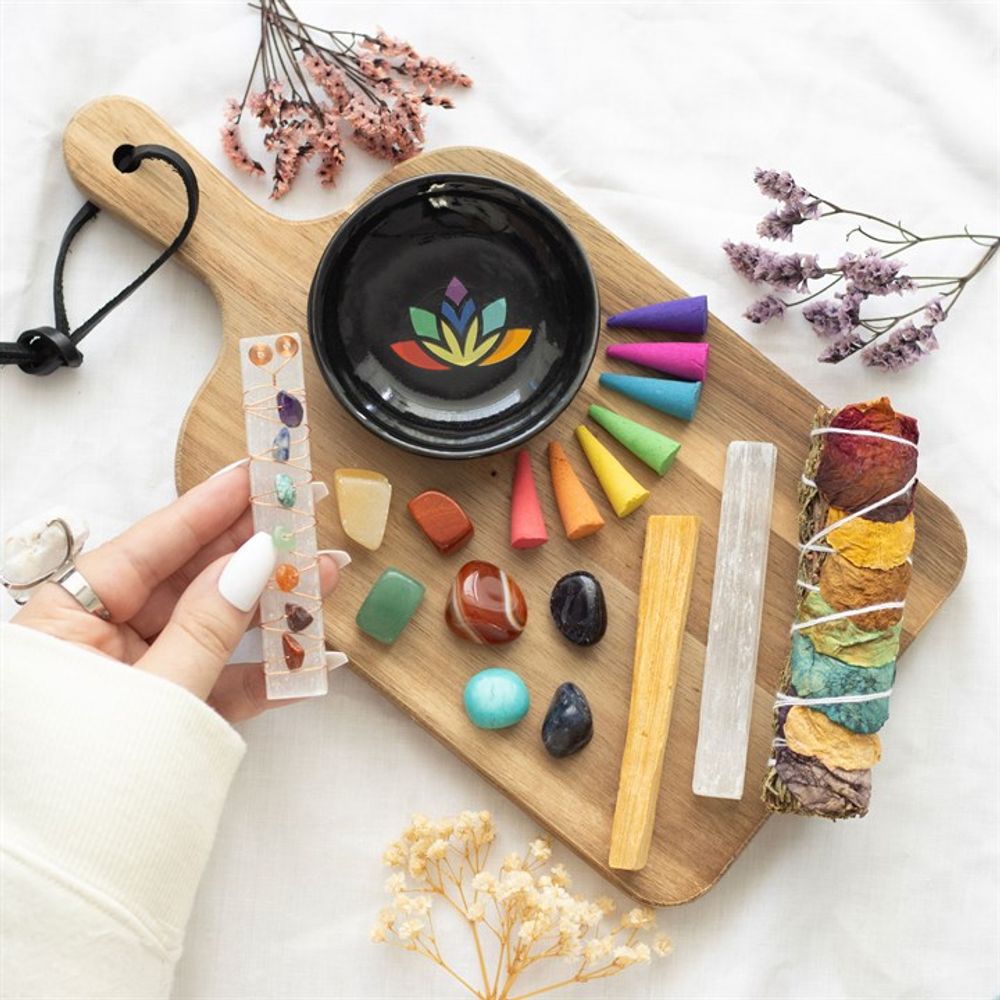 The colourful content of a crystal set on a wooden chopping board, a hand with white nails holding a crustal